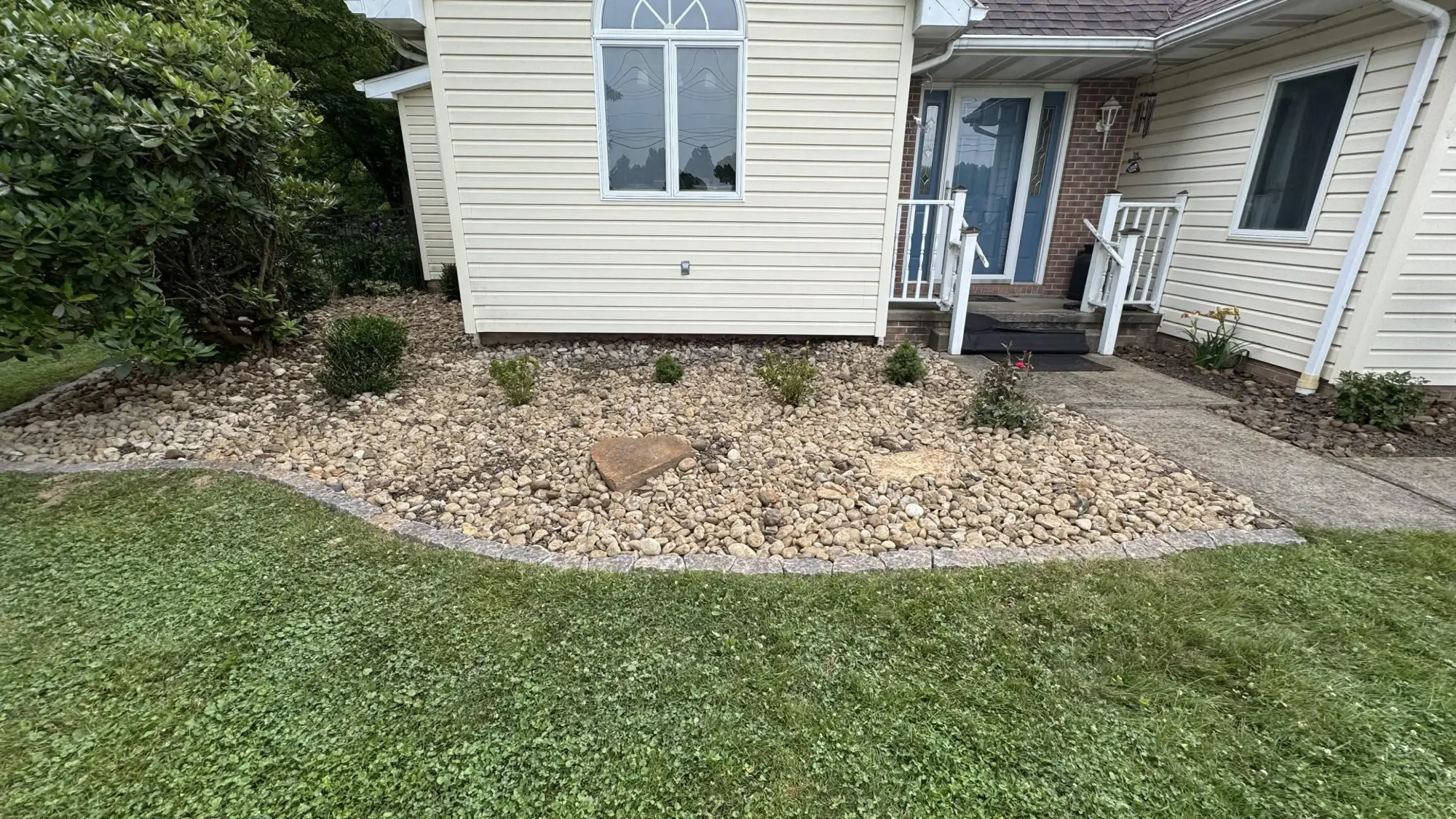 Rock bed after - clean river rock with stone edging