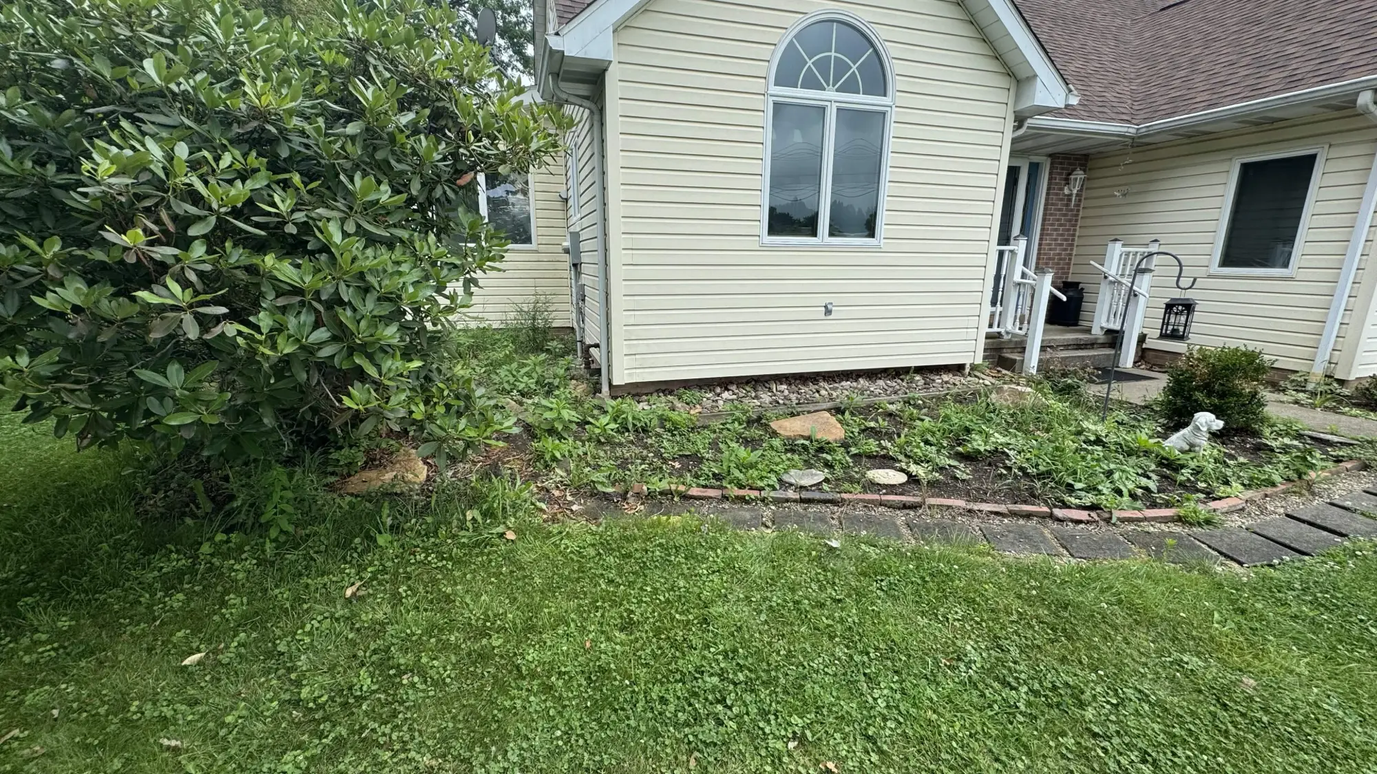 Rock bed before - overgrown weedy bed